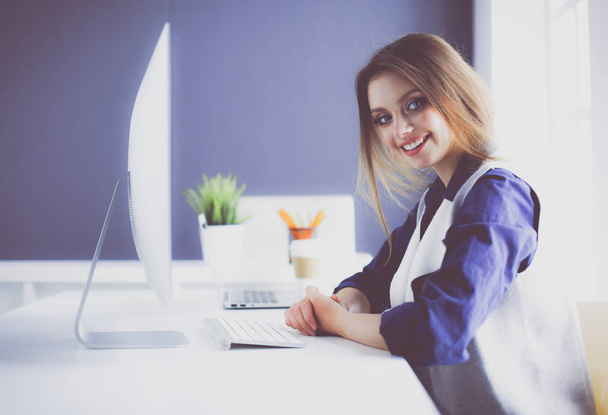 Young confident businesswoman working at office desk and typing with a laptop - Zdjęcie, obraz