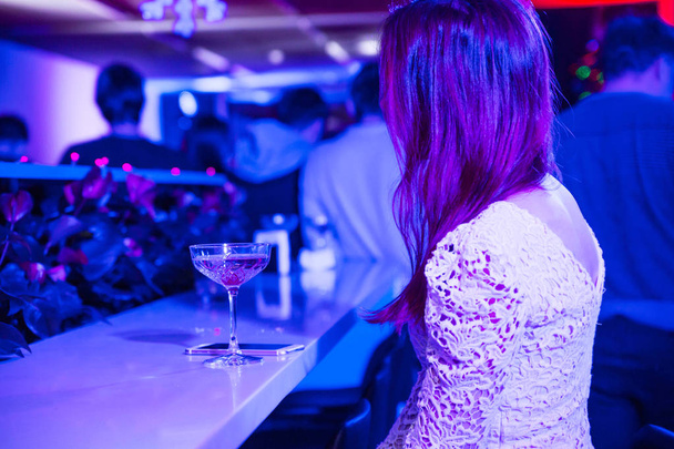 Osamělá dívka v nočním klubu. Horizontální Foto - Fotografie, Obrázek