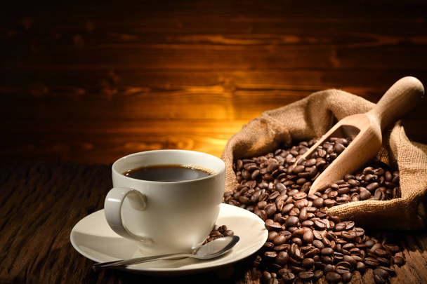 Kuppi kahvia ja kahvipapuja vanhalla puupohjalla - Valokuva, kuva