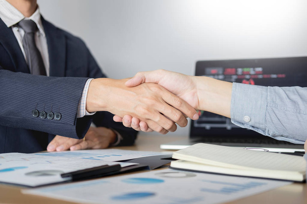 shaking Hand between businessman of cooperation over Stock market chart, business trading concept - Photo, Image