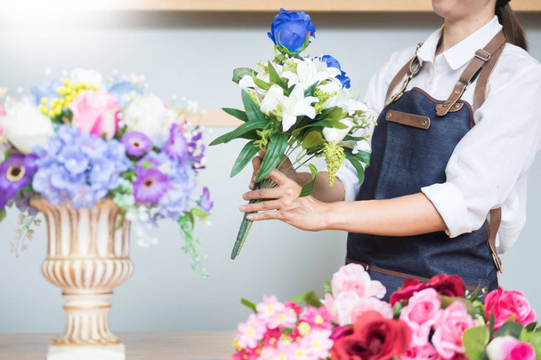 Női virágüzlet munkahelyi segítségével Arranging, így gyönyörű mesterséges csokor mellény virágbolt, üzleti, értékesítés és a kertművészet kézműves és kézzel készült koncepció - Fotó, kép