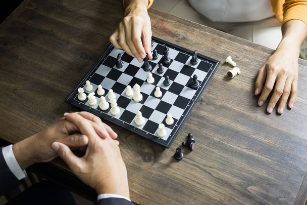 hand of businessman moving chess figure in competition board game for development analysis, strategy idea management or leadership concept - Photo, Image