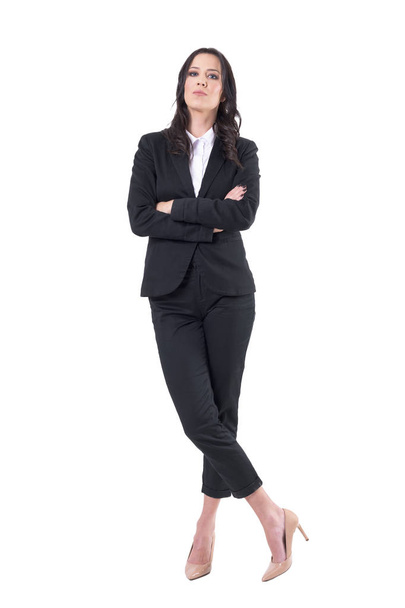 組んだ腕と胡坐立っている黒い服を着て自信を持ってビジネスの女性。全身白い背景に分離.  - 写真・画像