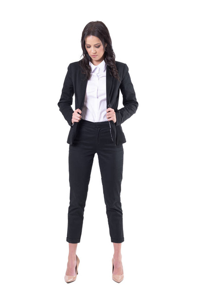 Mulher de negócios sincera se vestindo segurando terno preto desabotoado. Corpo inteiro isolado em fundo branco
.  - Foto, Imagem