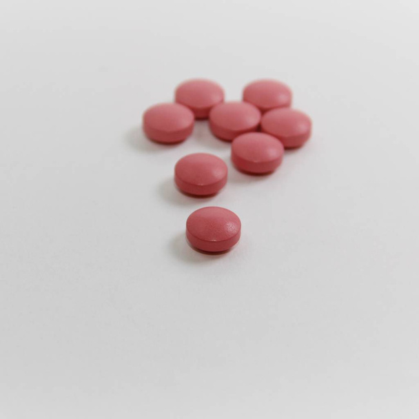 píldoras de color rosa sobre fondo blanco
 - Foto, imagen