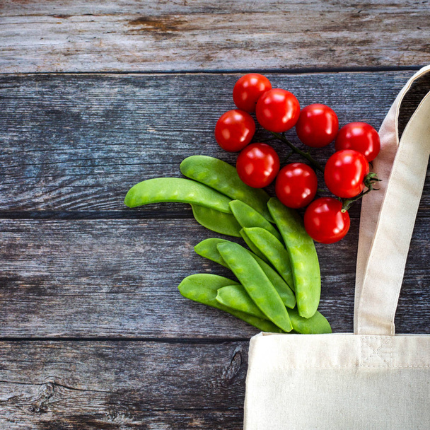 Öko-Einkaufstasche mit frischem Bio-Gemüse und Salat auf Holzgrund, von oben gesehen, flache Lage - Foto, Bild