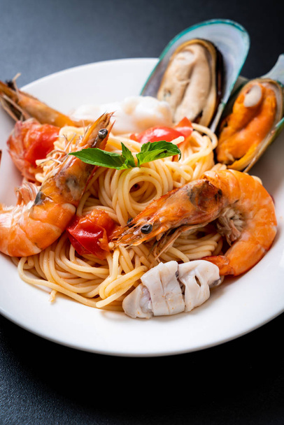 Seafood pasta Spaghetti with Clams, Prawns, Squis, Mussel and Tomatoes - Italian food style - 写真・画像
