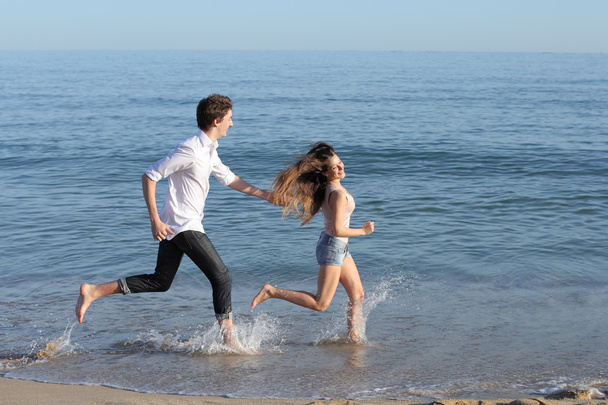 Couple chasing and running on the beach - Φωτογραφία, εικόνα