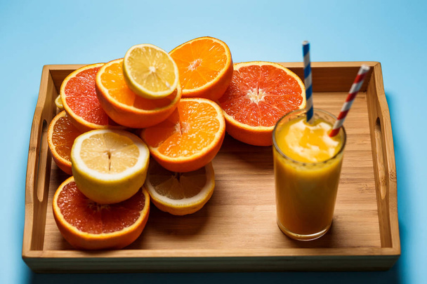 cut in half juicy citruses on a blue background - Foto, Imagen