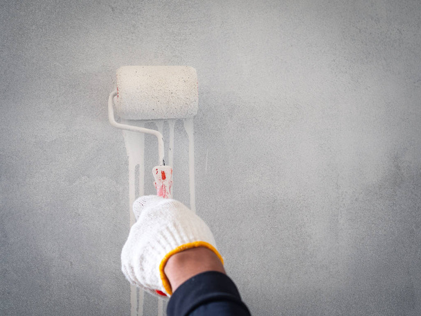 close up de mão do trabalhador usando rolo e escova para pintura de parede. Conceito de edifício
. - Foto, Imagem