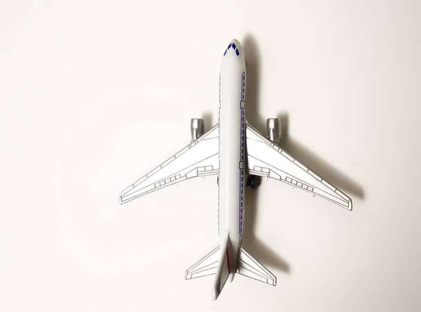 gray model airplane on grey background with copy space.  flat lay design  - Zdjęcie, obraz