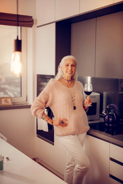 Cheerful aged woman relaxing alone at home - Photo, Image