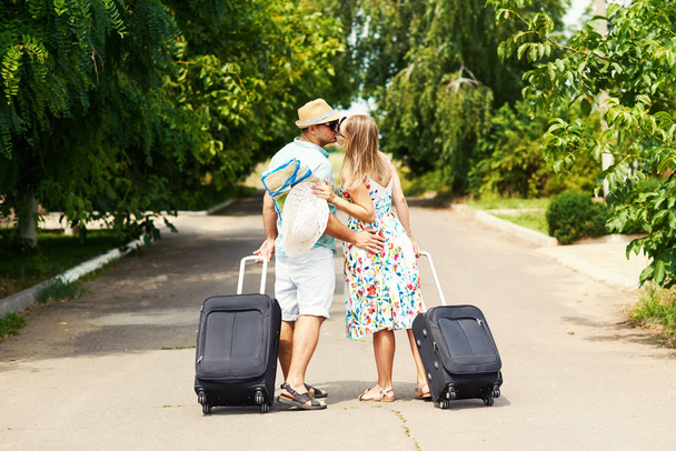 Romantic couple on way in airport. Attractive young woman and handsome man with suitcases are ready for summer traveling. - 写真・画像