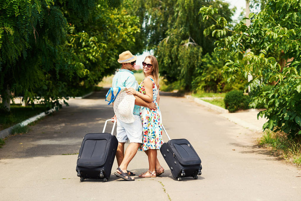 Romantic couple on way in airport. Attractive young woman and handsome man with suitcases are ready for summer traveling. - Фото, зображення