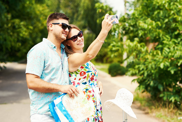 travel, vacation, technology, summer and people concept - smiling couple with smartphone traveling  and making selfie - Фото, изображение