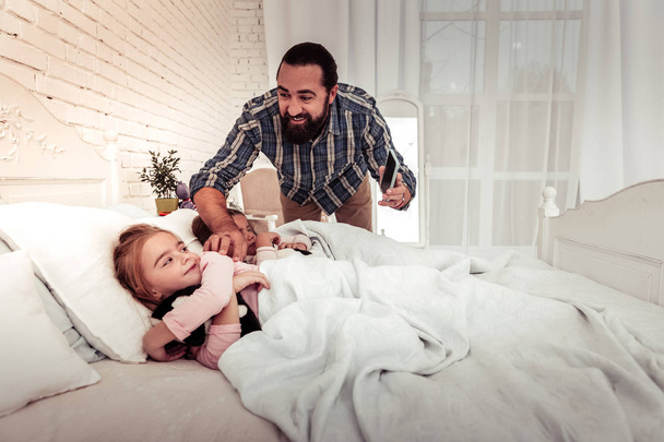 Delighted happy man waking up his daughter - Fotó, kép