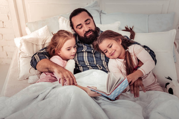 Delighted happy girls choosing a bedtime story - Foto, imagen