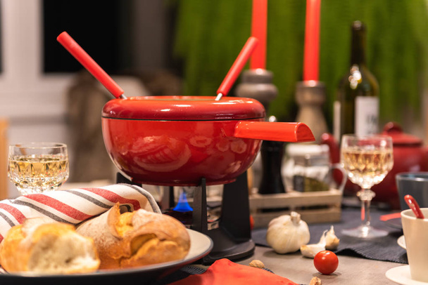 Perinteinen sveitsiläinen juusto fondue punainen potti betoni ruokapöytä
. - Valokuva, kuva