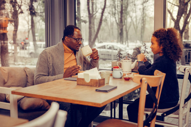 Father and daughter eating and drinking tea together after walking - 写真・画像