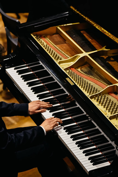 Χέρια του κλασικός πιανίστας που παίζει το πιάνο του κατά τη διάρκεια μιας συναυλίας. - Φωτογραφία, εικόνα