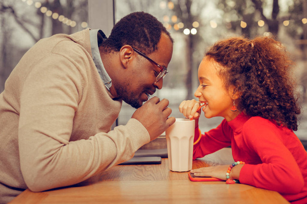 Father and daughter drinking milk cocktail together - 写真・画像