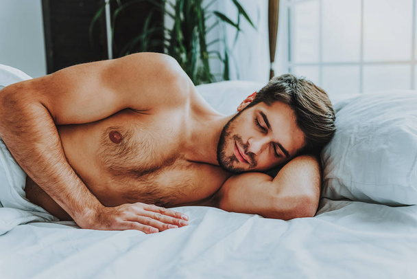 Young guy having nap in bed at home - Fotografie, Obrázek