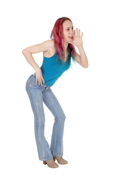 A slim young woman standing in jeans and blue top with her han - Photo, Image