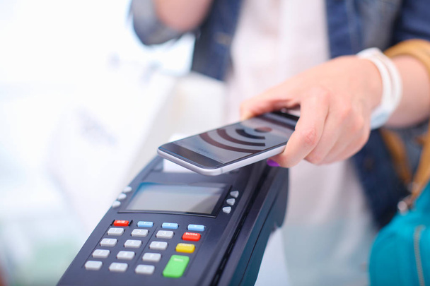 Customer is paying with smartphone in shop using NFC technology. NFC technology. Customer is paying - Φωτογραφία, εικόνα
