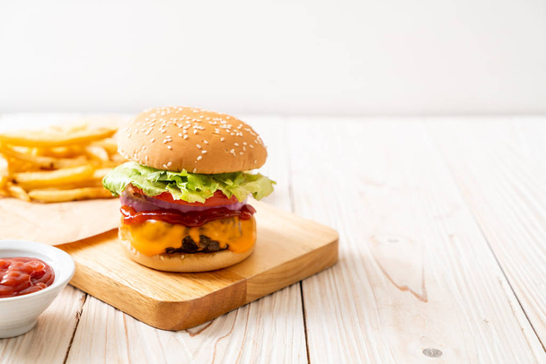 fresh tasty beef burger with cheese and ketchup on wood background - Foto, Bild