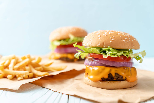 Świeża wołowina smaczne burger z serem i frytki na tle drewna - Zdjęcie, obraz