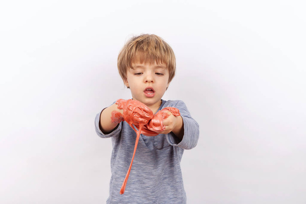 Funny small boy playing with slime. - Foto, imagen