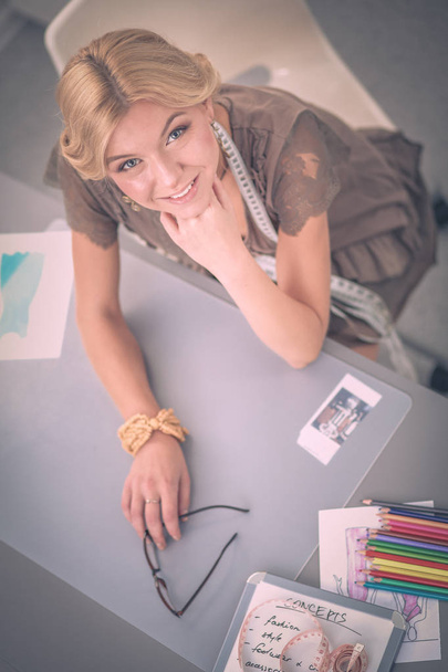 Young woman fashion designer working at studio. - Foto, afbeelding