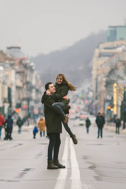 Young carefree happy people. Caucasian young students. Guy and girl. Love. Walk together on the european street in winter road. Theme love and happiness at a young age. - Valokuva, kuva