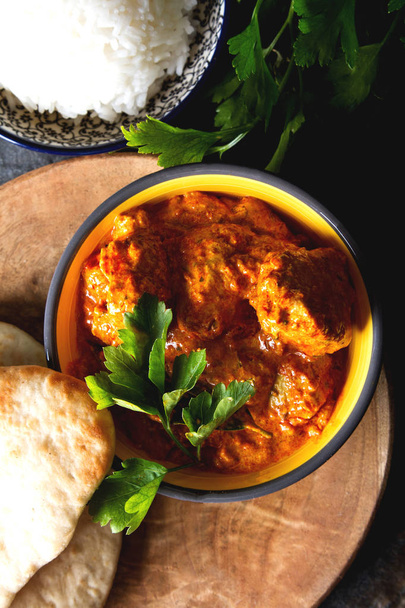Chicken tikka masala spicy curry meat food Butter chicken with rice and naan bread on dark background close-up.  - Fotoğraf, Görsel