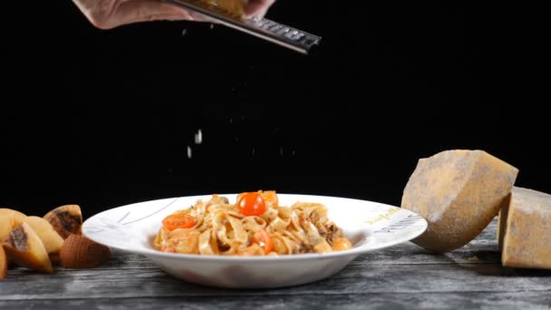 Koch reibt Hartkäse. Kochen von Meeresfrüchten Pasta. Zeitlupe eines Kochreibekäses, typisch italienischer Käse, Pasta auf Teller, frisch gekochtes Konzept: italienische Küche, Käse, Restaurant und Lebensmittel - Filmmaterial, Video