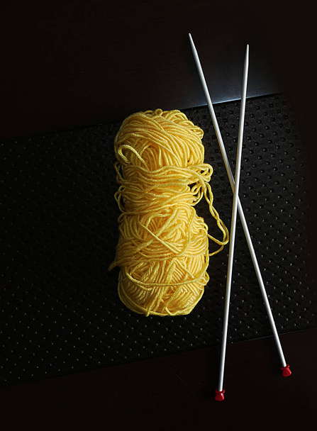 ručně pletená, pletací jehlice na černém pozadí a žlutý Orlon, Orlon lano pro výrobu ruční pletení, orlon lano ve žluté barvě, - Fotografie, Obrázek