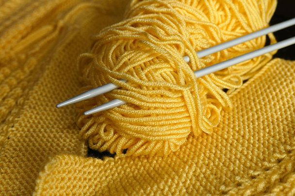 вязание ручной работы, вязальные спицы на черном фоне и желтый Орлон, верёвка Орлон для изготовления вязания рук, верёвка Орлон желтого цвета
, - Фото, изображение