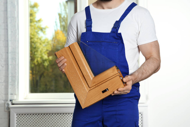 Installation worker with sample of modern window profile indoors - Foto, afbeelding