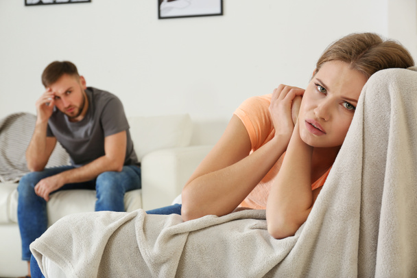 Young couple ignoring each other after argument in living room. Relationship problems - Zdjęcie, obraz