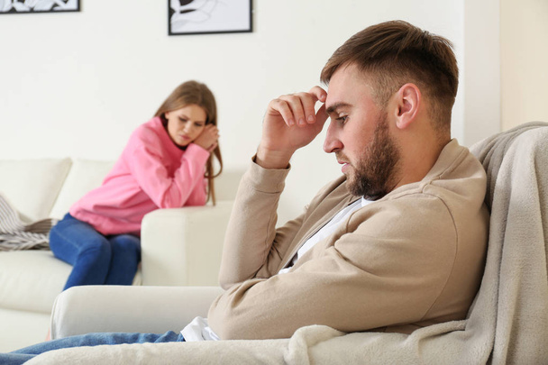 Young couple ignoring each other after argument in living room. Relationship problems - Foto, afbeelding