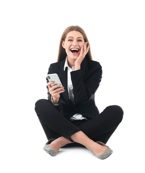 Emotional businesswoman in office wear with smartphone celebrating victory on white background - Foto, imagen