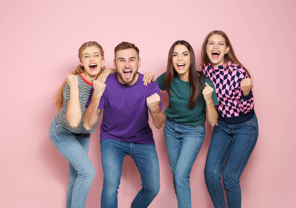 Young people celebrating victory on color background - Foto, imagen