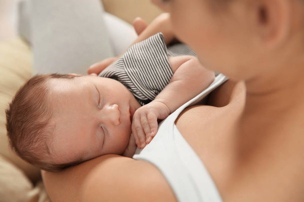 Young woman holding her newborn baby, closeup - Fotografie, Obrázek