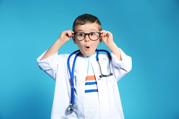 Cute child in doctor coat with stethoscope on color background - Φωτογραφία, εικόνα