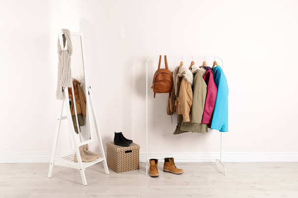 Modern hallway interior with mirror and clothes on hanger stand - Фото, зображення