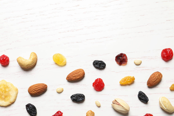 Flat lay composition of different dried fruits and nuts on wooden background. Space for text - Fotoğraf, Görsel