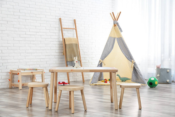 Cozy kids room interior with table, stools and play tent - Foto, Imagen