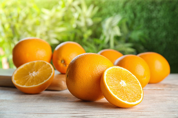 Fresh juicy oranges on wooden table. Healthy fruits - Фото, изображение