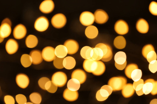 Beautiful golden lights on dark background. Bokeh effect - Foto, Imagem