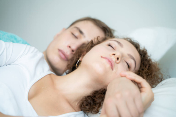 Beautiful young man and women love couple hugging on bed in morning - Photo, Image